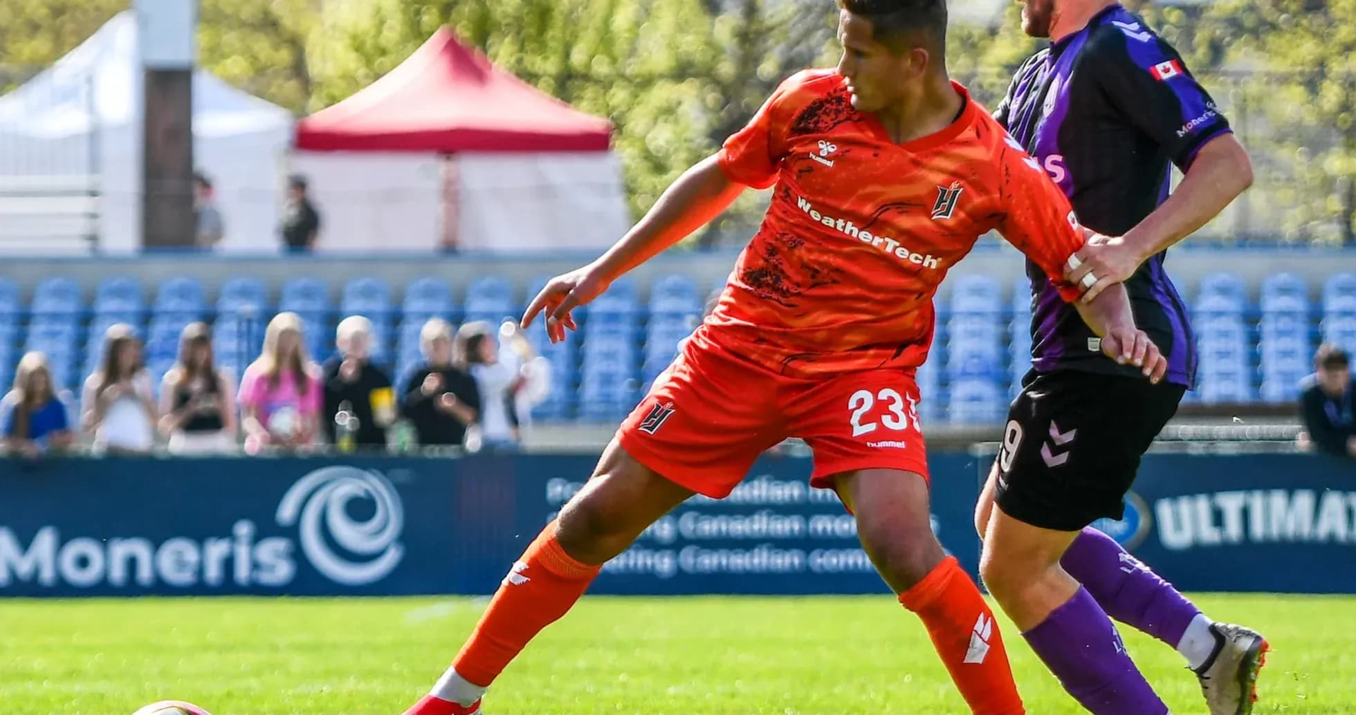 Player in orange jersey dribbling the ball Player in orange jersey dribbling the ball