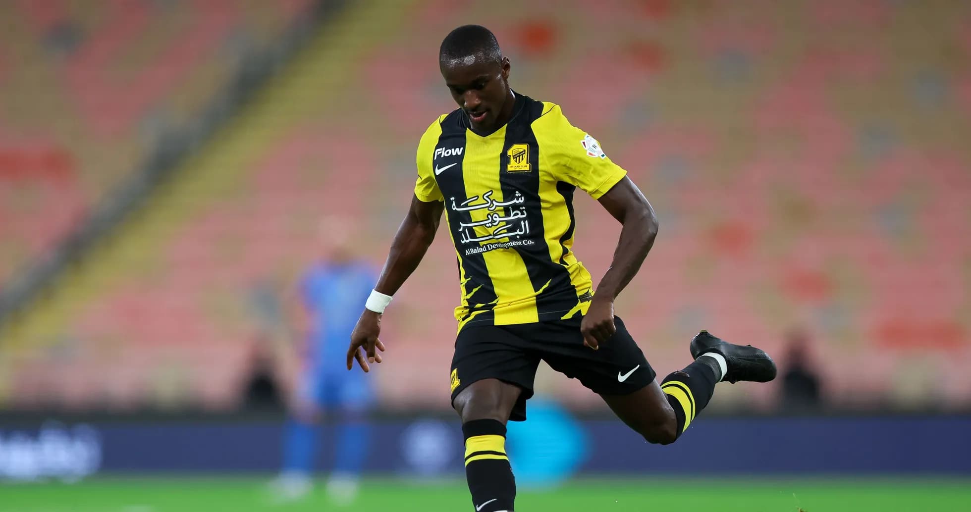 Player in yellow and black kit kicking the ball Player in yellow and black kit kicking the ball