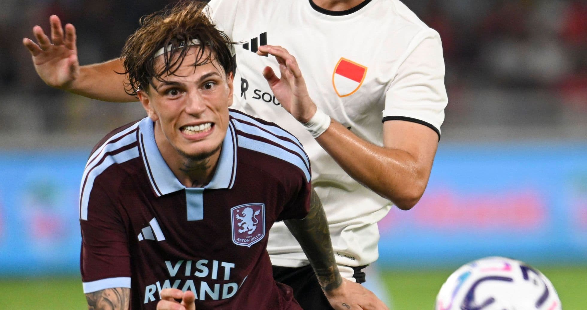 Aston Villa player challenged by opponent during match Aston Villa player challenged by opponent during match