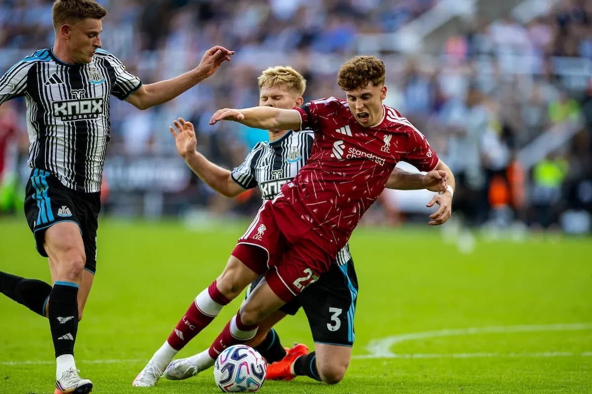 Newcastle player challenges Liverpool player for ball Newcastle player challenges Liverpool player for ball