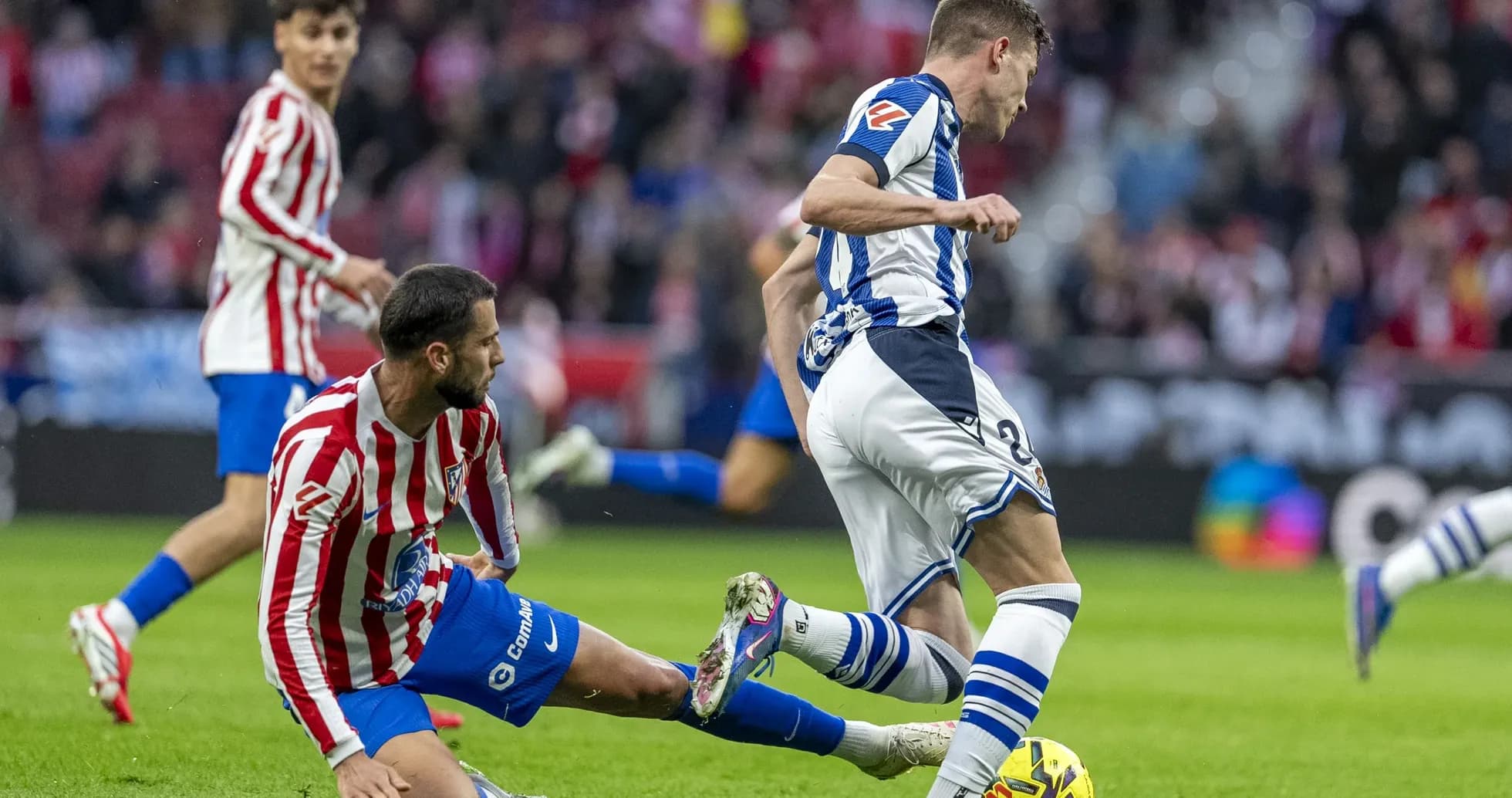 Real Sociedad player evading Atletico Madrid tackle Real Sociedad player evading Atletico Madrid tackle