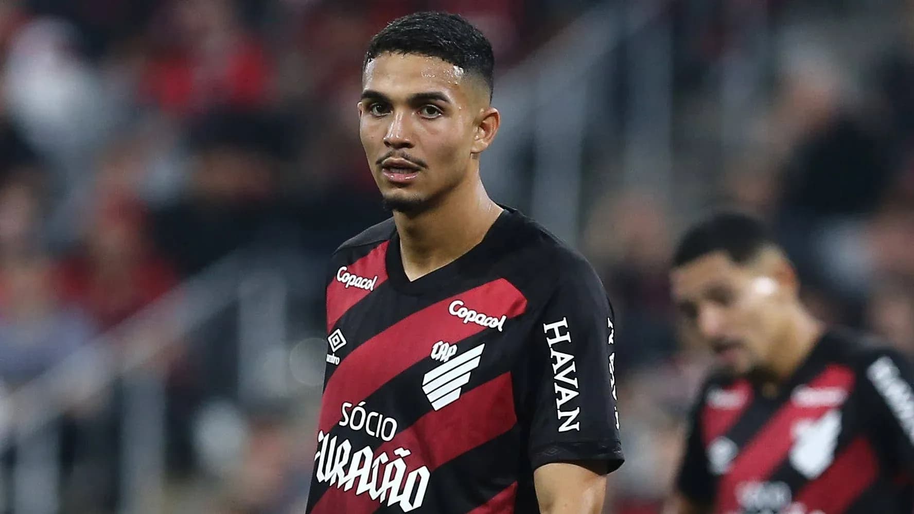 Player in black and red jersey on field Player in black and red jersey on field