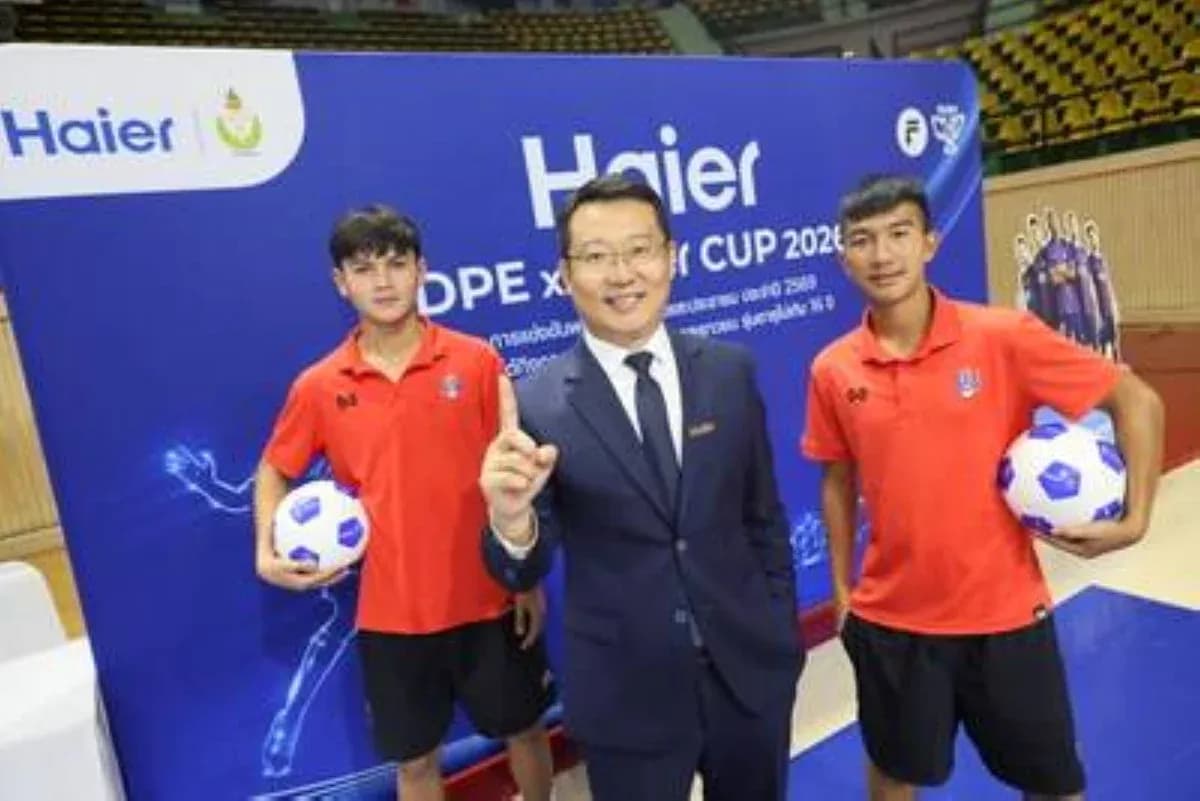 Two players holding soccer balls with event representative Two players holding soccer balls with event representative