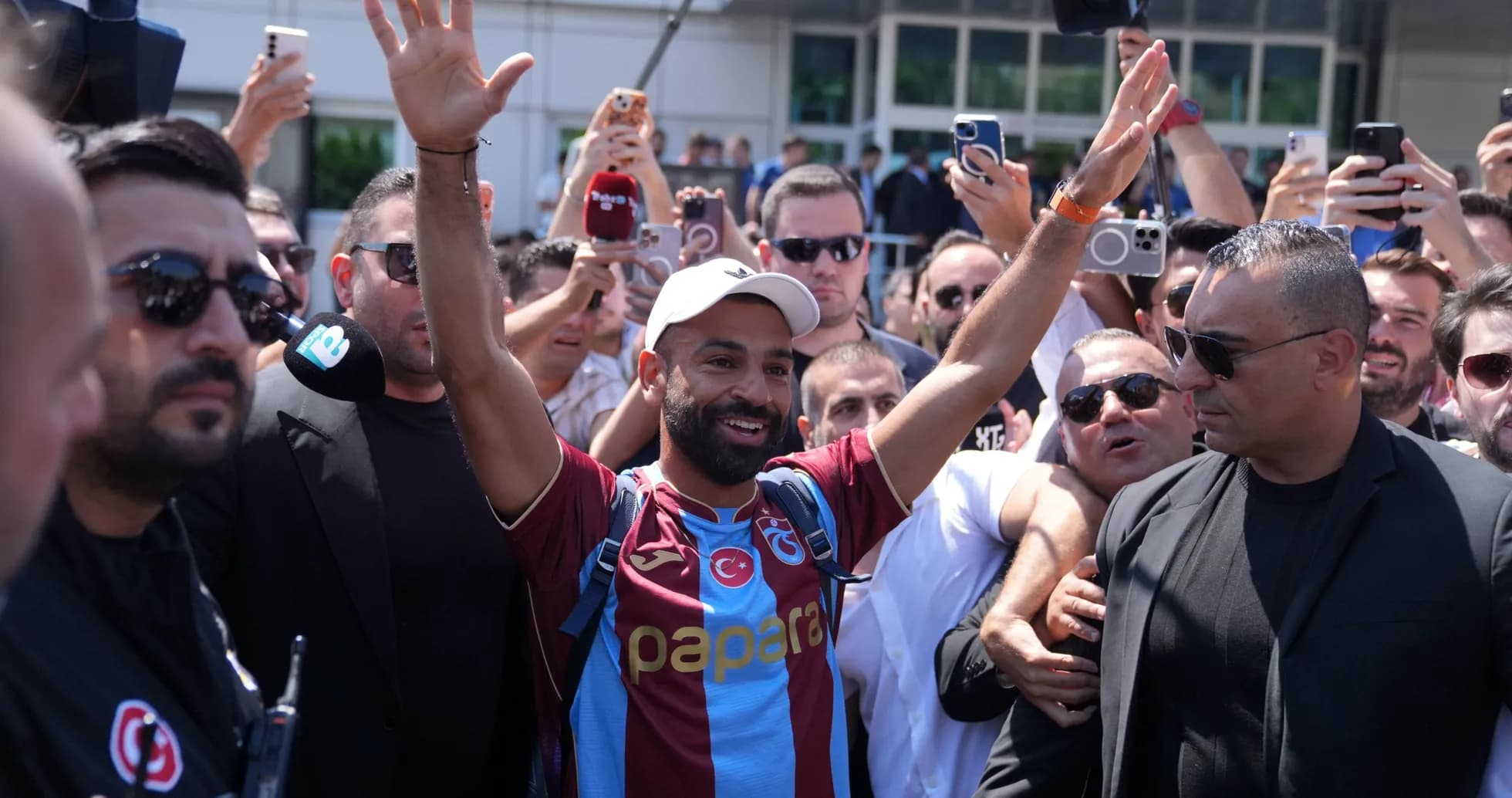 Player greeting fans surrounded by crowd and security Player greeting fans surrounded by crowd and security