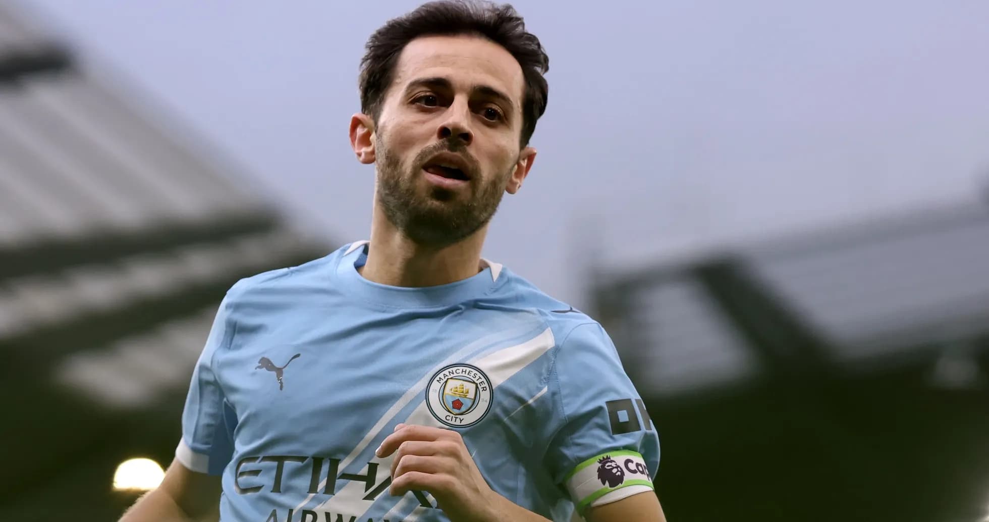 Player in Manchester City kit running on field Player in Manchester City kit running on field