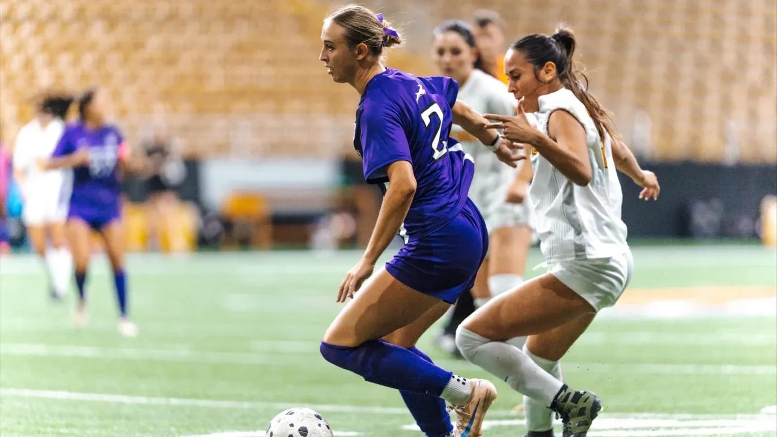 Two players competing for the ball on the field Two players competing for the ball on the field