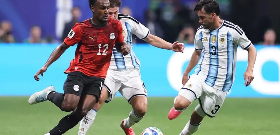 Egyptian player dribbling past Argentine defenders during match Egyptian player dribbling past Argentine defenders during match