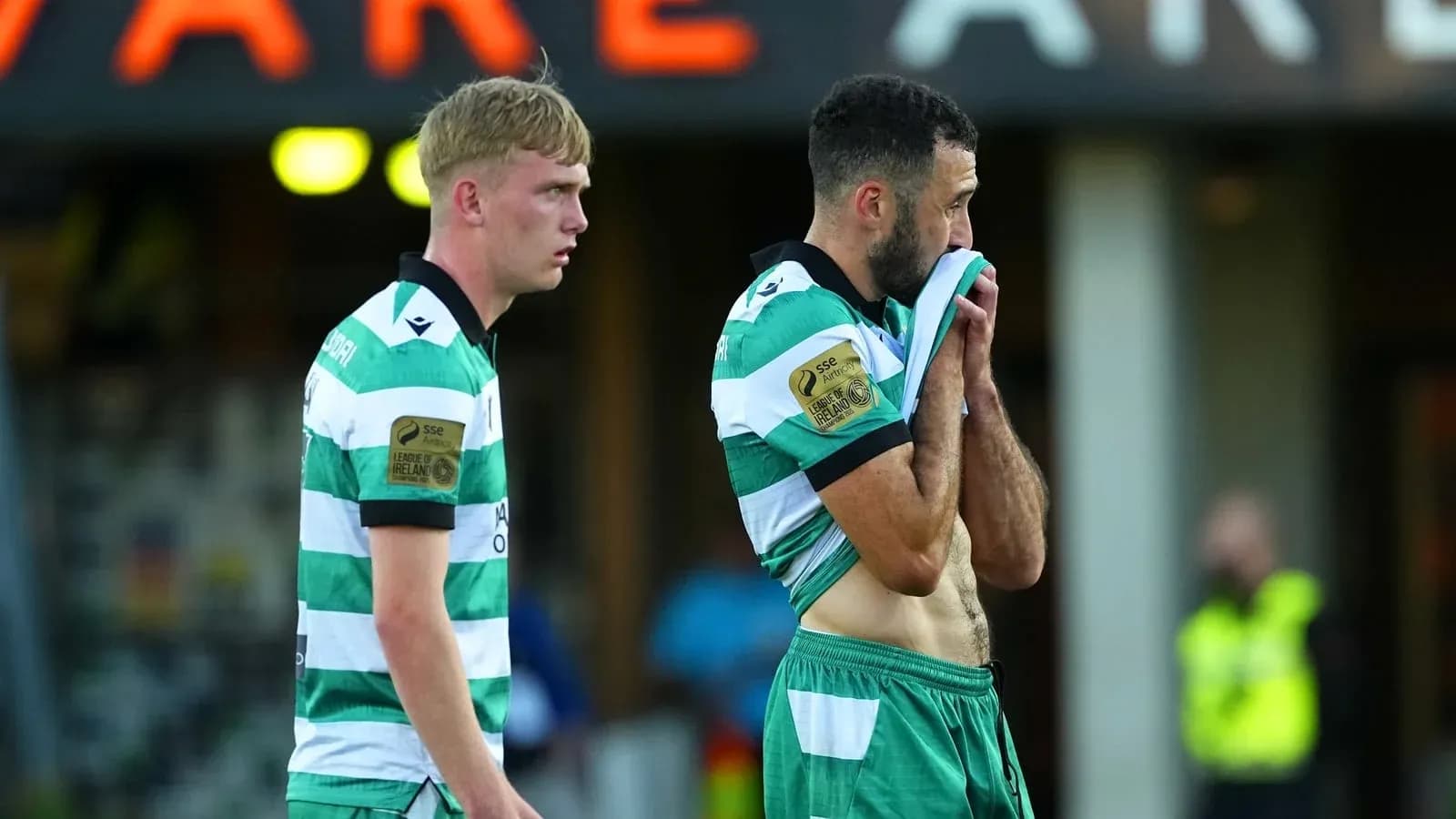 Two players in green and white jerseys after match Two players in green and white jerseys after match
