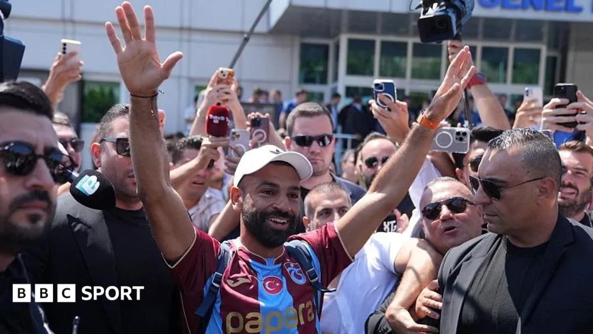 Player greeting fans outside stadium with raised hands Player greeting fans outside stadium with raised hands