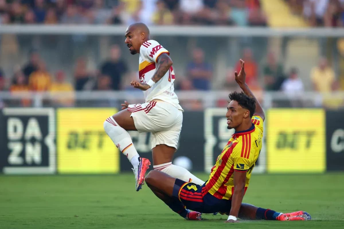 Lecce player tackling AS Roma opponent during match Lecce player tackling AS Roma opponent during match