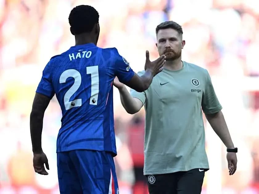 Player in blue jersey greeting coach on the field Player in blue jersey greeting coach on the field