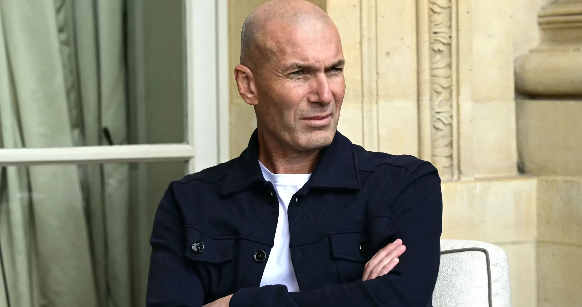 Man sitting with arms crossed in casual attire Man sitting with arms crossed in casual attire