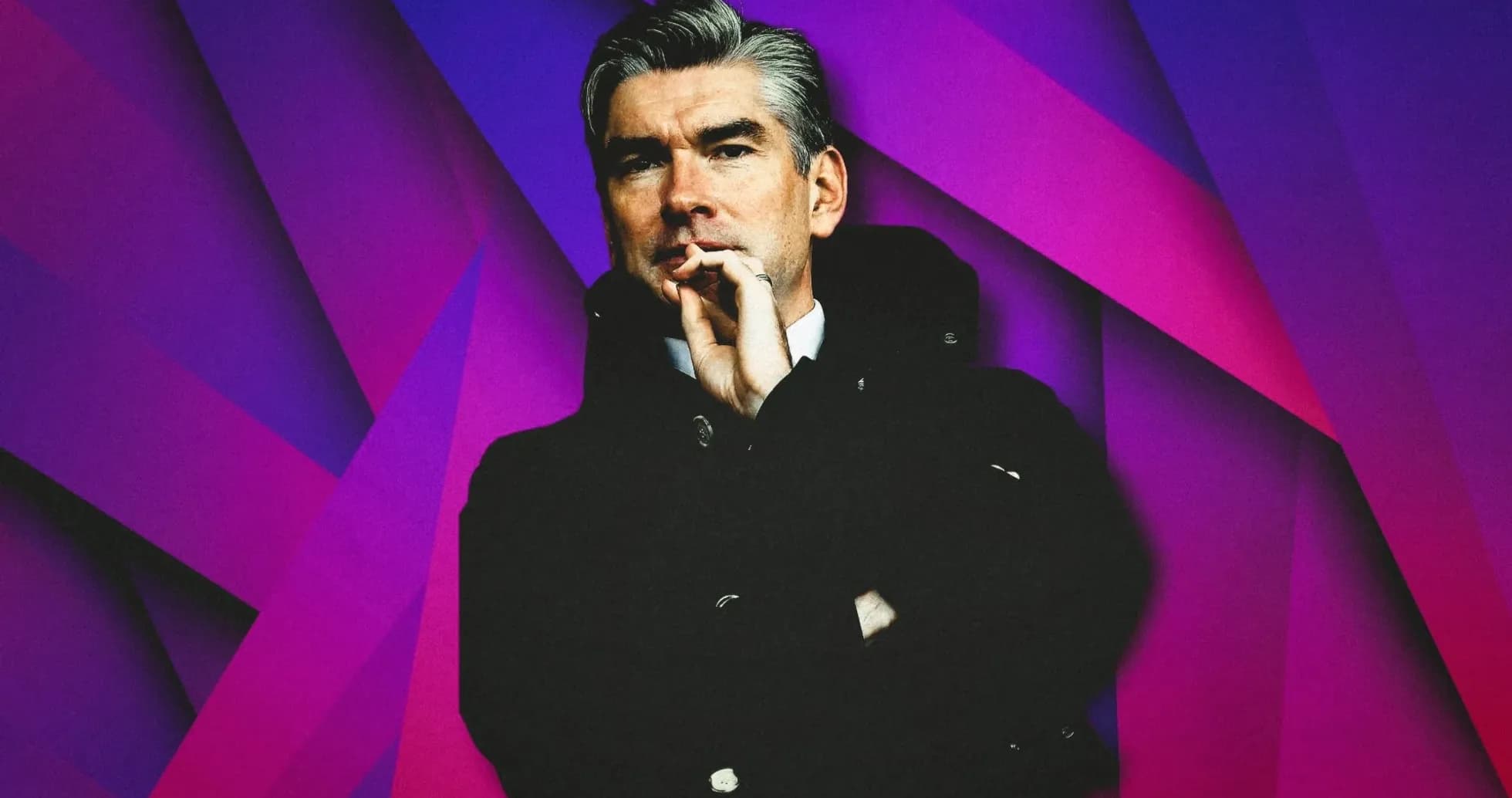 Man in black coat with hand on chin Man in black coat with hand on chin
