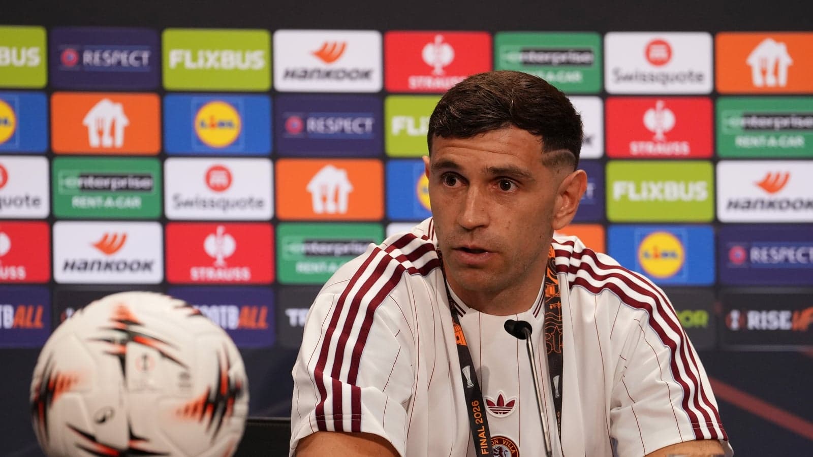 Player speaking at press conference with football Player speaking at press conference with football