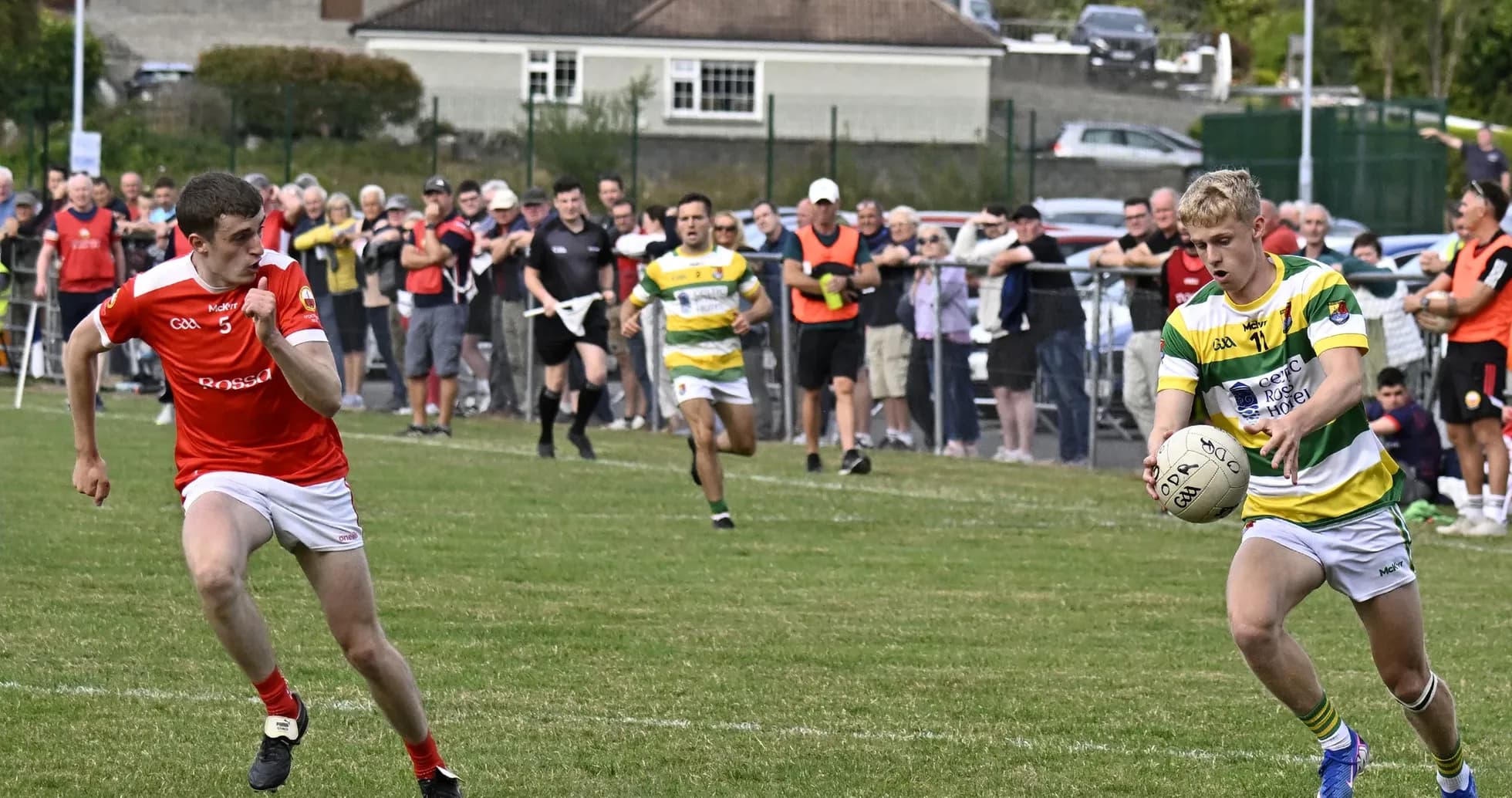 Player in green and yellow jersey with ball, pursued Player in green and yellow jersey with ball, pursued