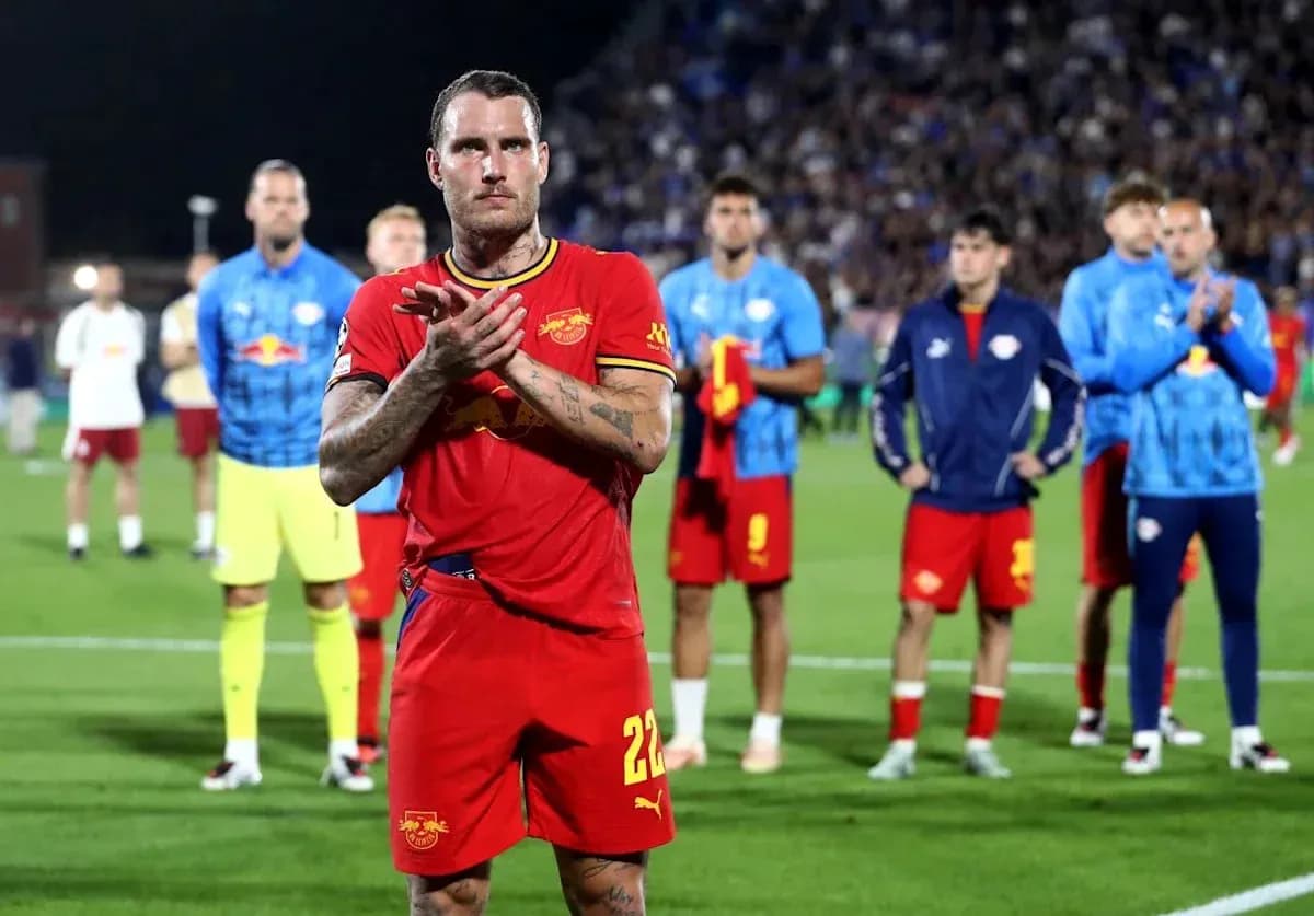 Player applauding with teammates in background after match Player applauding with teammates in background after match