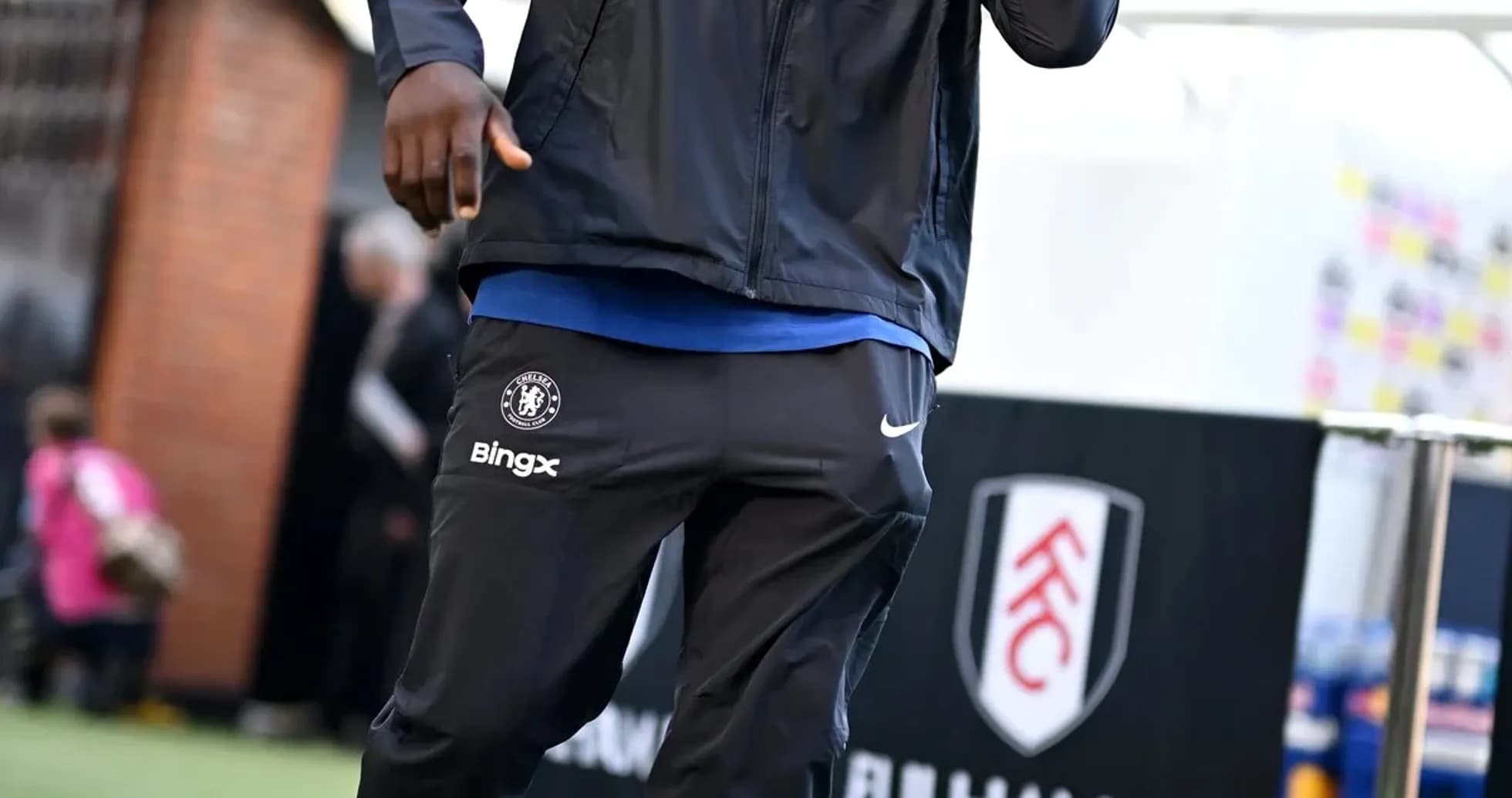 Player walking towards stadium entrance in team gear Player walking towards stadium entrance in team gear