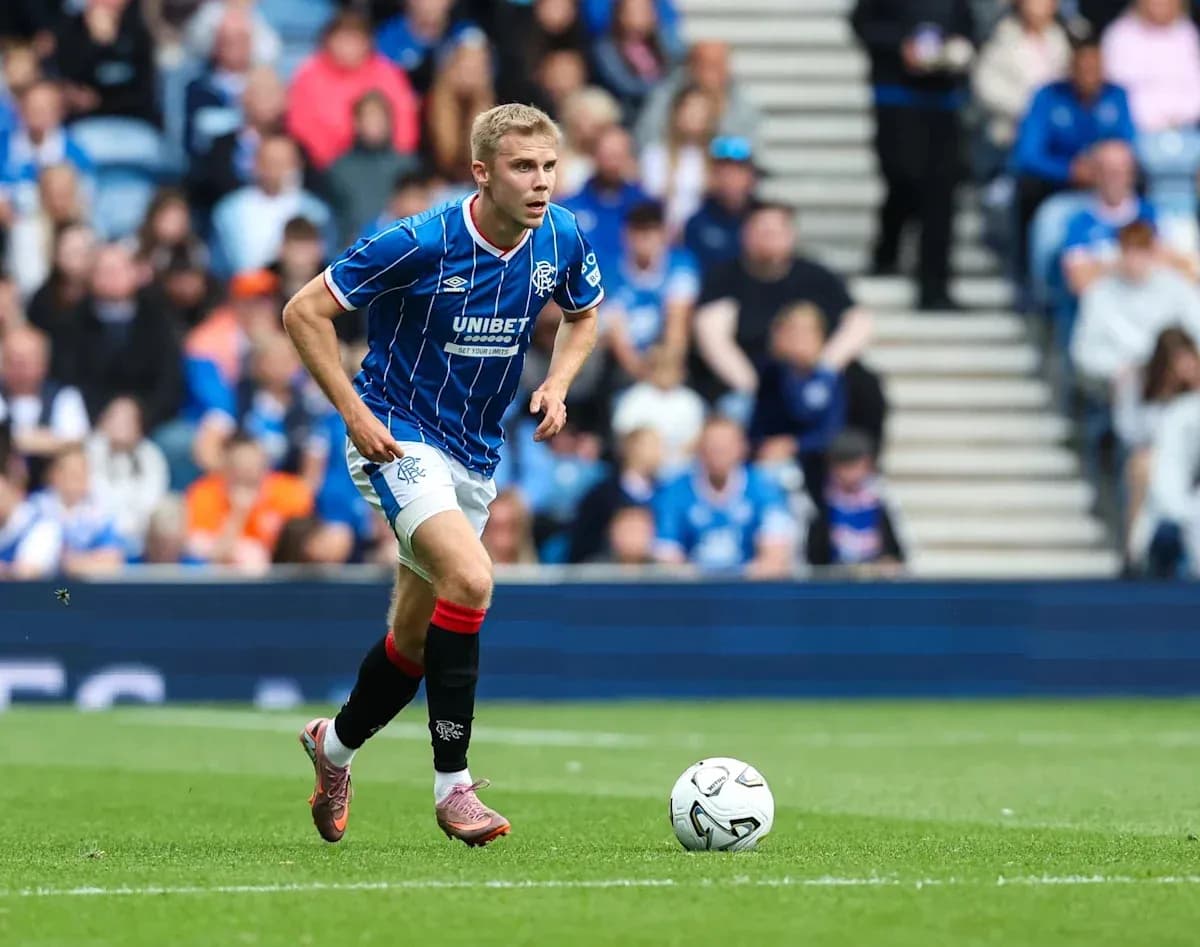 Player in blue kit running towards soccer ball Player in blue kit running towards soccer ball