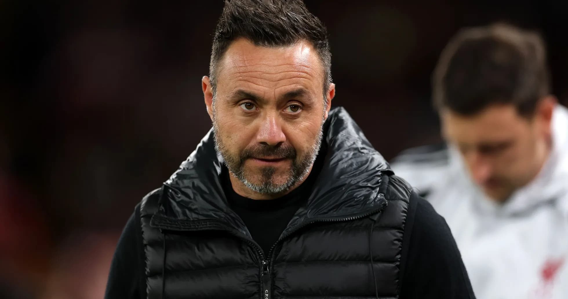 Coach wearing a black puffer vest on sidelines Coach wearing a black puffer vest on sidelines