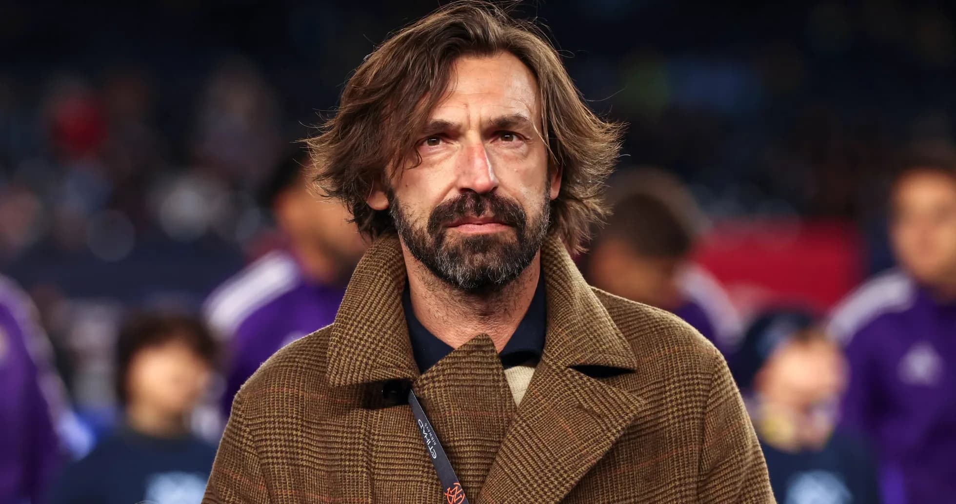 Coach in a brown coat at match event Coach in a brown coat at match event