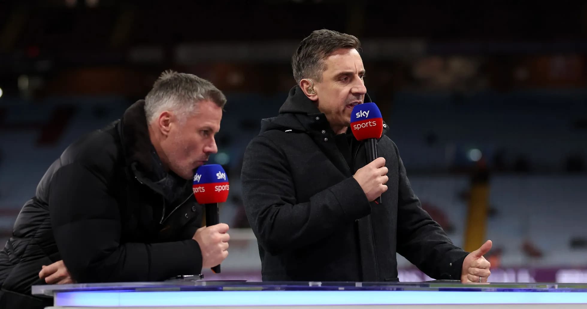 Two sports commentators speaking at broadcast desk Two sports commentators speaking at broadcast desk