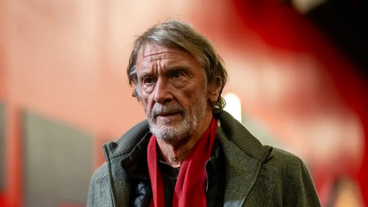 Man in gray coat with red scarf indoors Man in gray coat with red scarf indoors