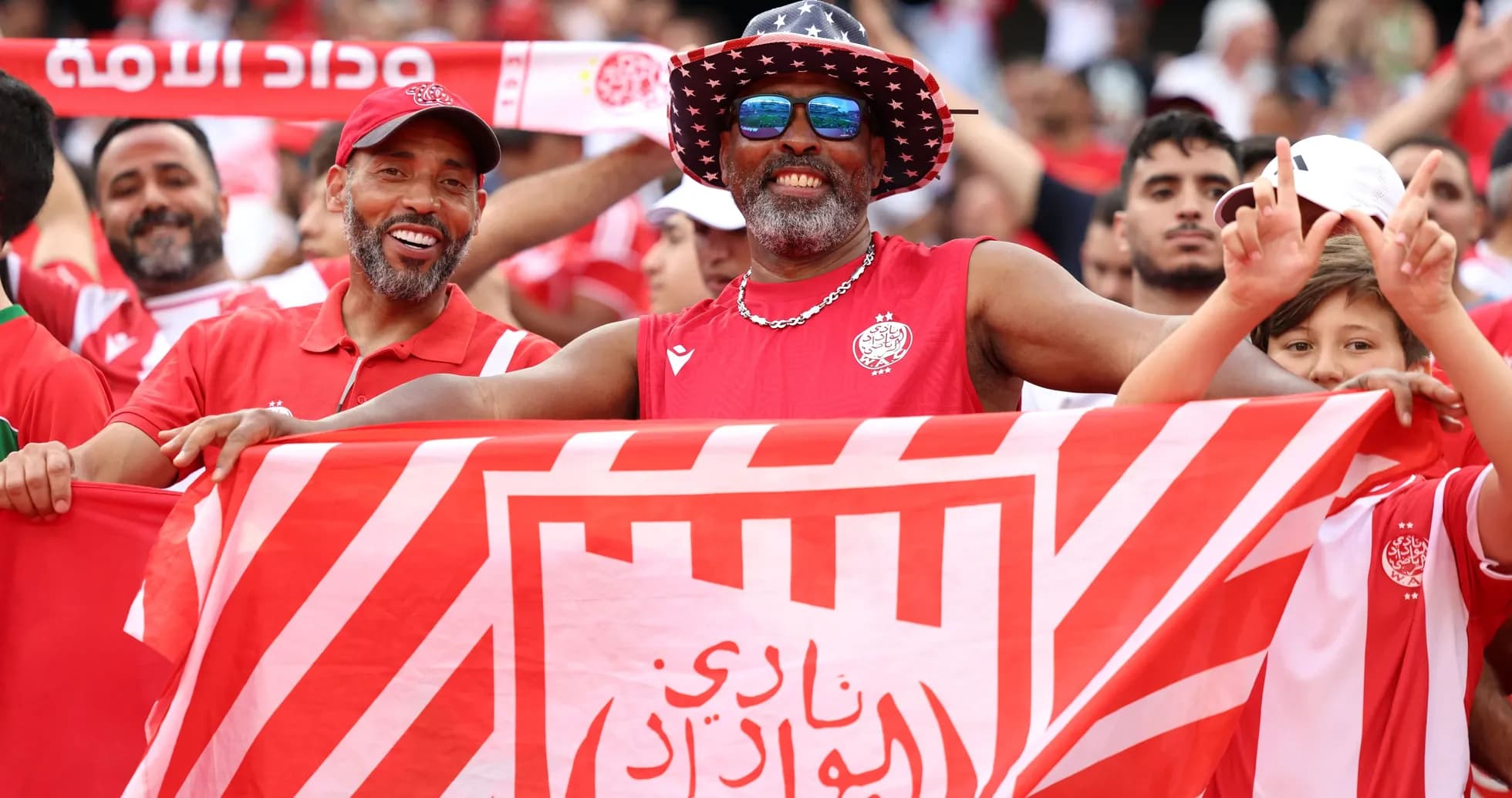 Fans celebrating with a flag at a match Fans celebrating with a flag at a match