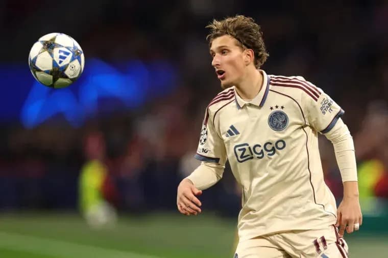Player in Ajax kit tracking the ball during match Player in Ajax kit tracking the ball during match