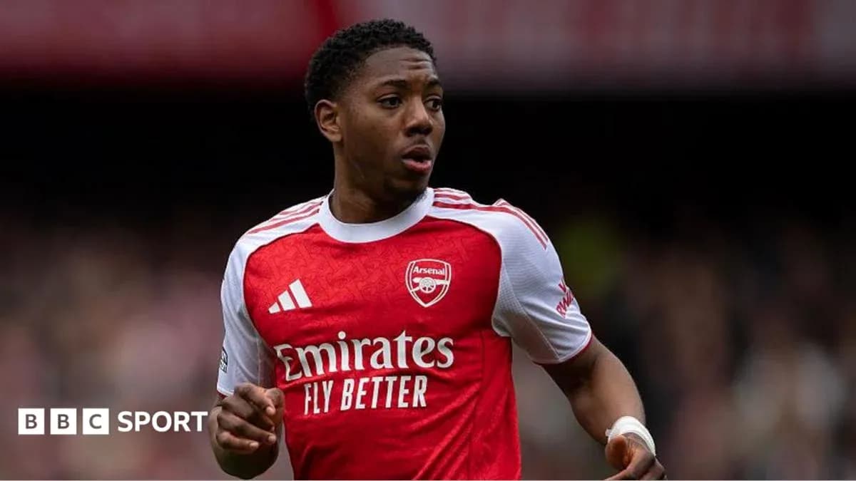 Player in Arsenal kit running on the pitch Player in Arsenal kit running on the pitch