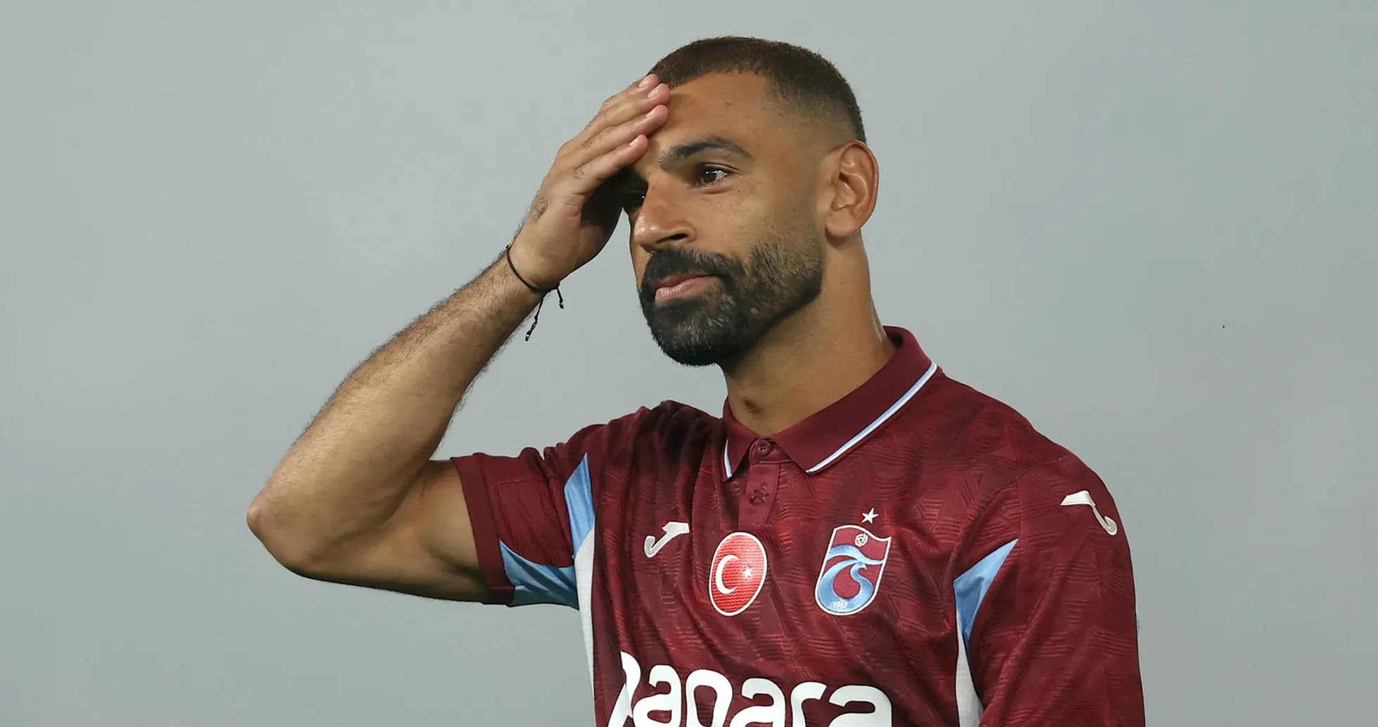 Player in maroon jersey touching his forehead Player in maroon jersey touching his forehead