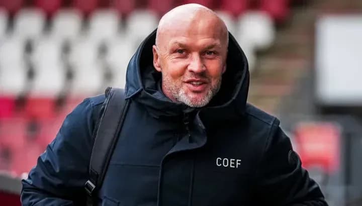 Man in coat smiling while walking at stadium Man in coat smiling while walking at stadium