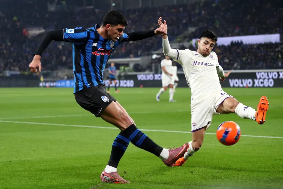 Fiorentina player tackling Atalanta opponent Fiorentina player tackling Atalanta opponent