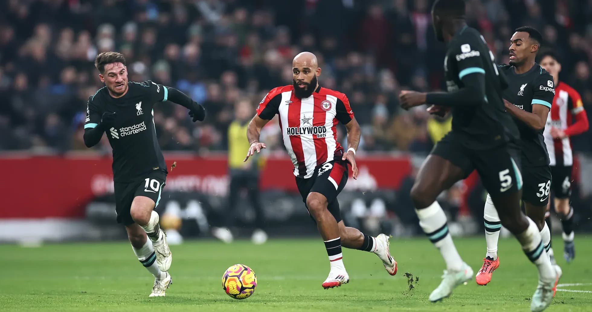 Liverpool players chasing Brentford forward with ball Liverpool players chasing Brentford forward with ball