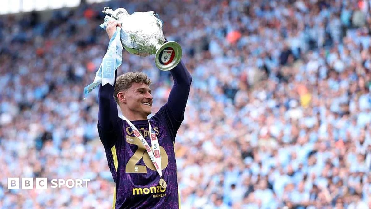 Player celebrating with trophy in stadium crowd Player celebrating with trophy in stadium crowd