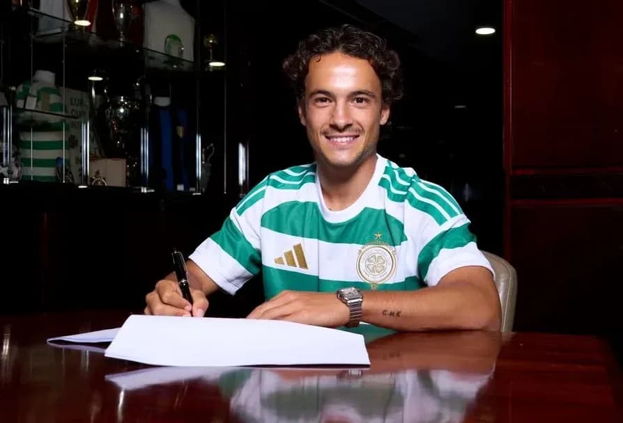 Player signing contract in Celtic jersey at table Player signing contract in Celtic jersey at table
