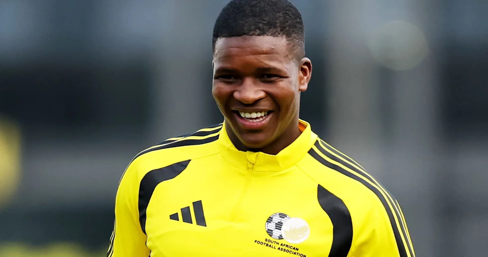 Player smiling in yellow training kit during session Player smiling in yellow training kit during session