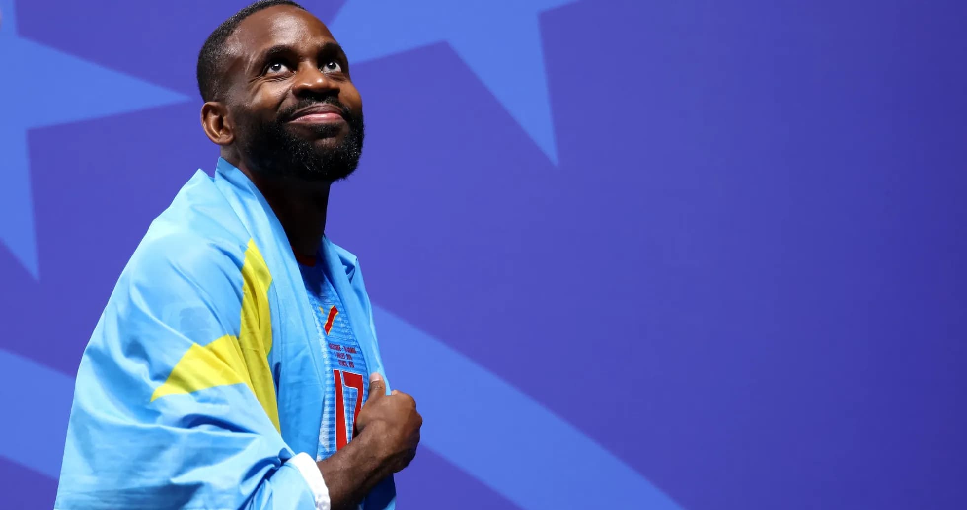 Athlete wearing flag, looking upward at event Athlete wearing flag, looking upward at event
