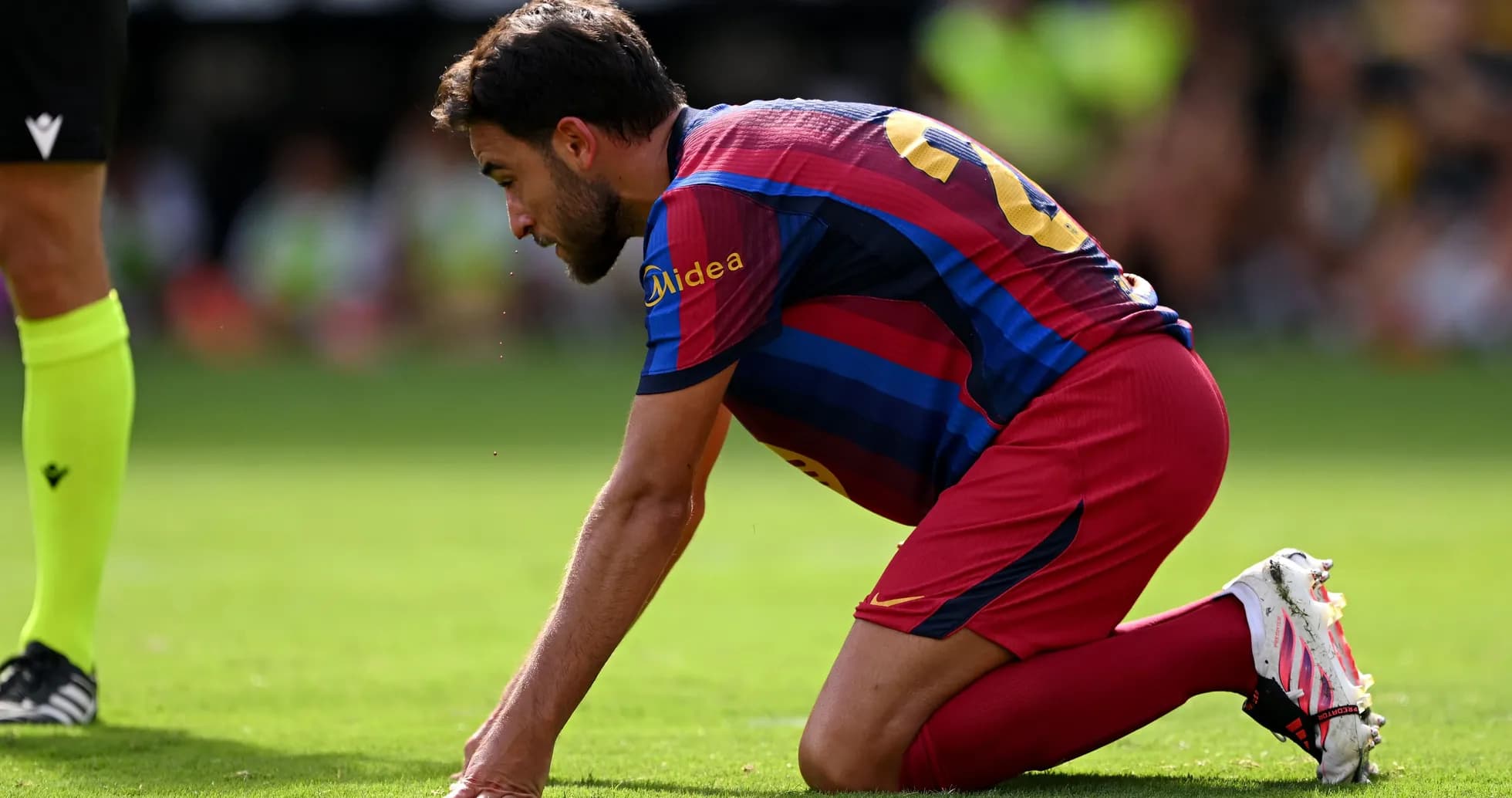 Player kneeling on pitch during a match Player kneeling on pitch during a match