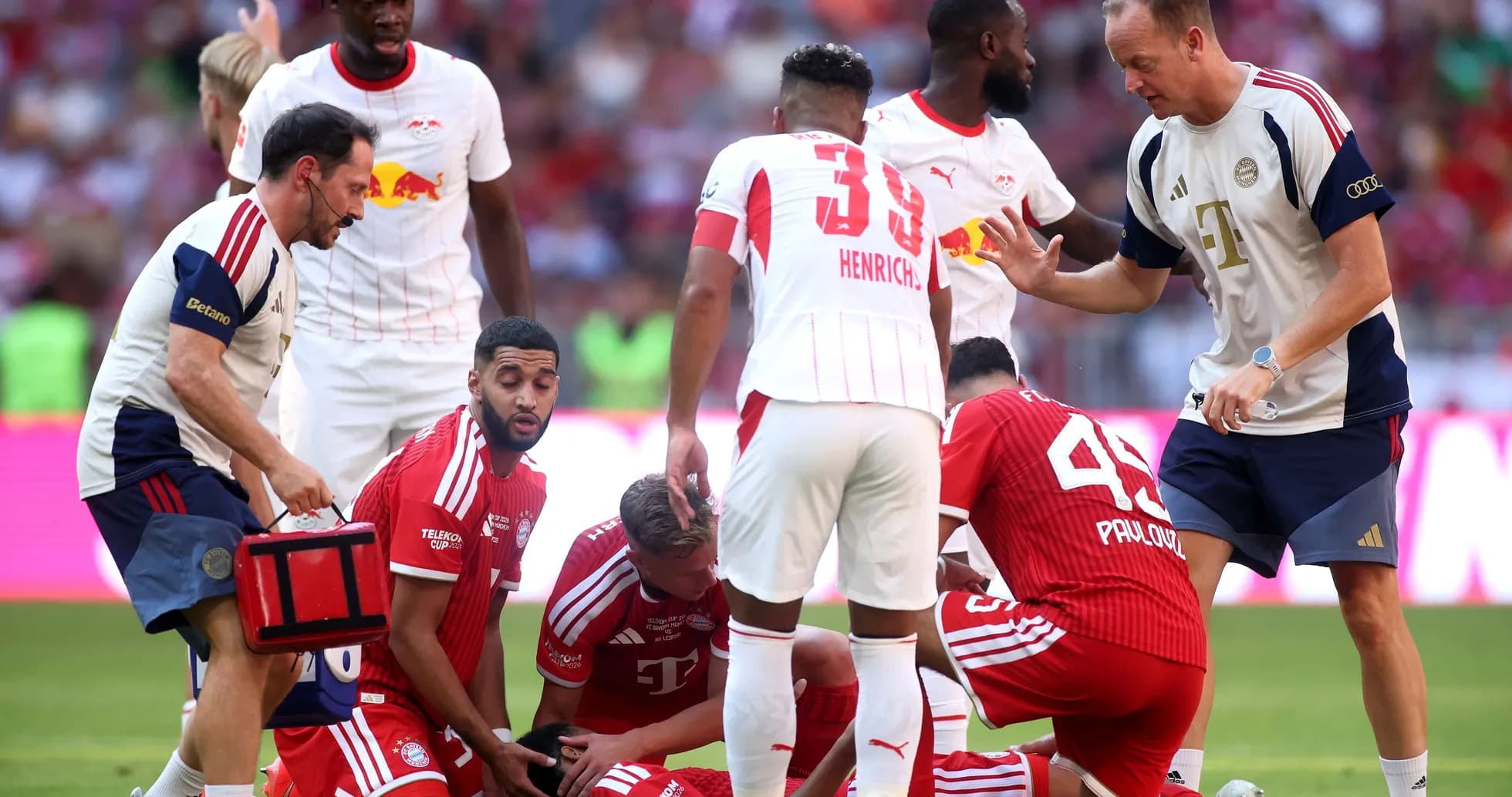 Players attending to an injured teammate on field Players attending to an injured teammate on field
