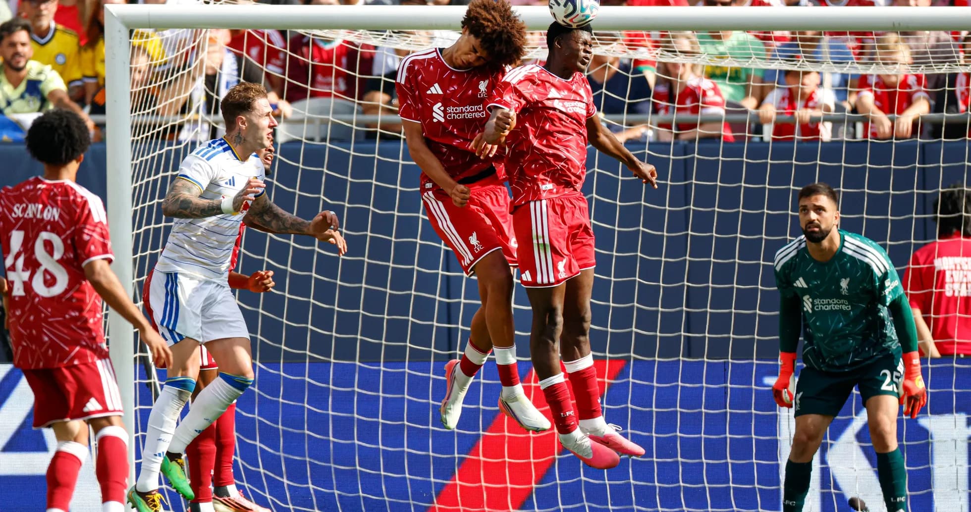 Two Liverpool players jumping for a header in goal area Two Liverpool players jumping for a header in goal area
