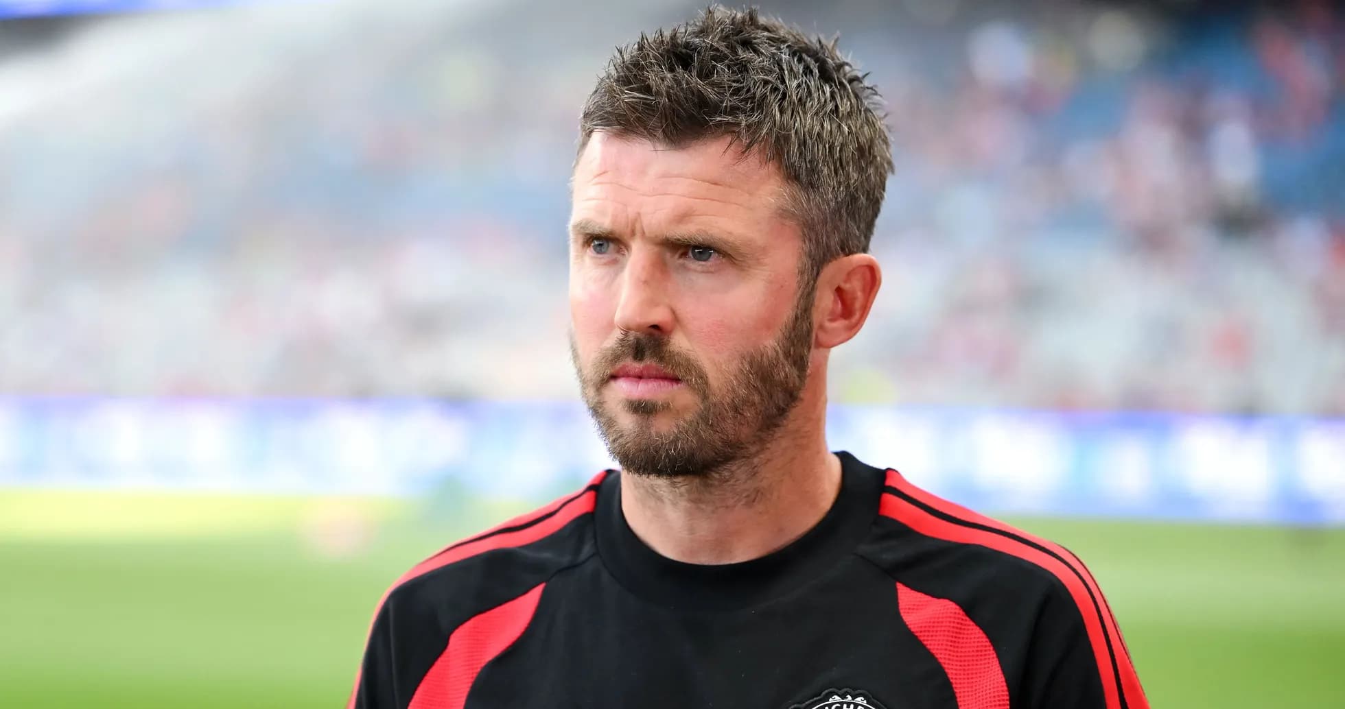Coach wearing Manchester United training gear on pitch Coach wearing Manchester United training gear on pitch