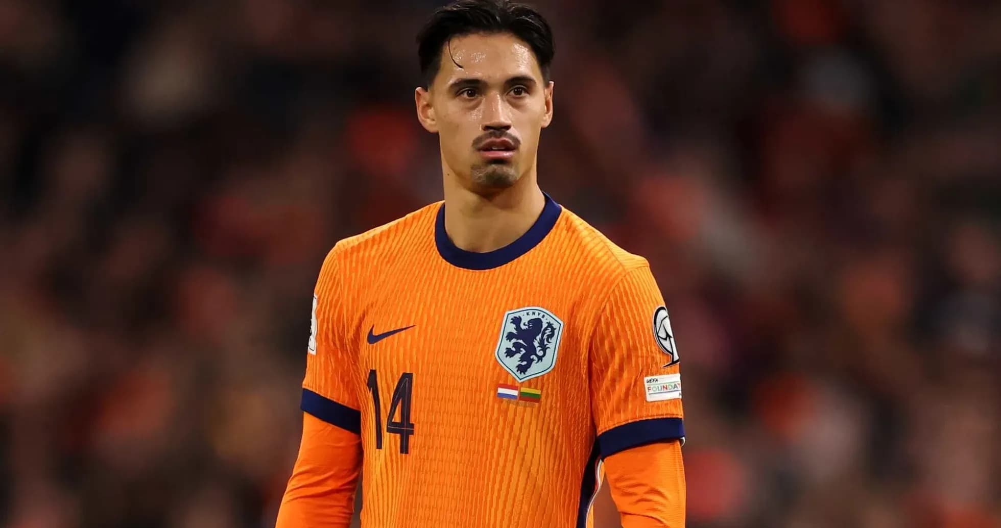 Player in orange jersey during a football match Player in orange jersey during a football match