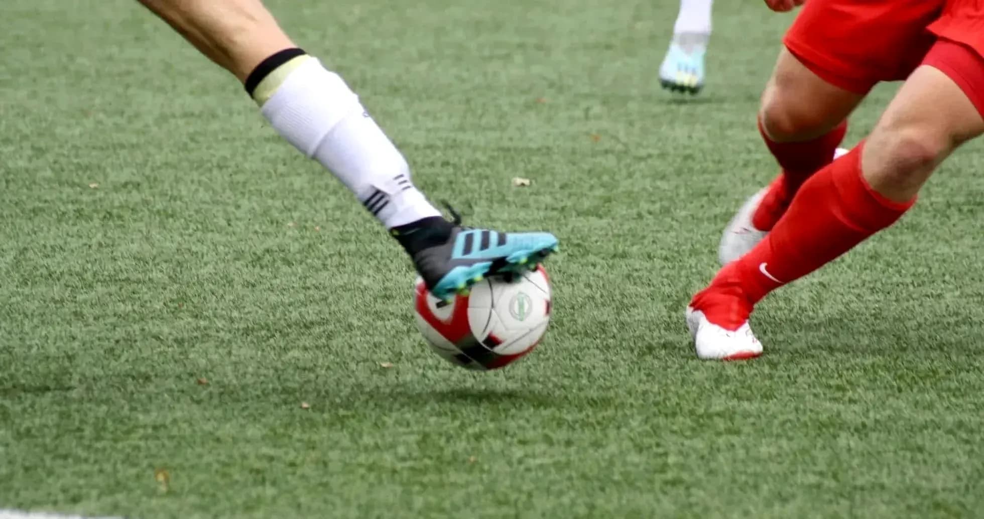 Two players competing for the ball in football Two players competing for the ball in football