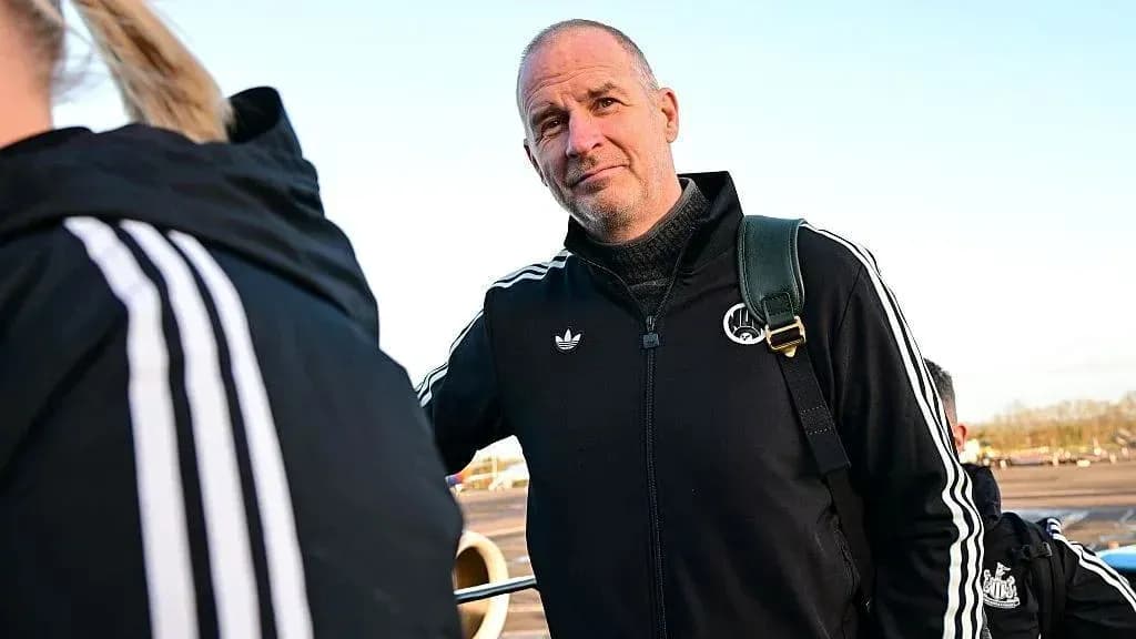 Coach standing at airport with team members Coach standing at airport with team members