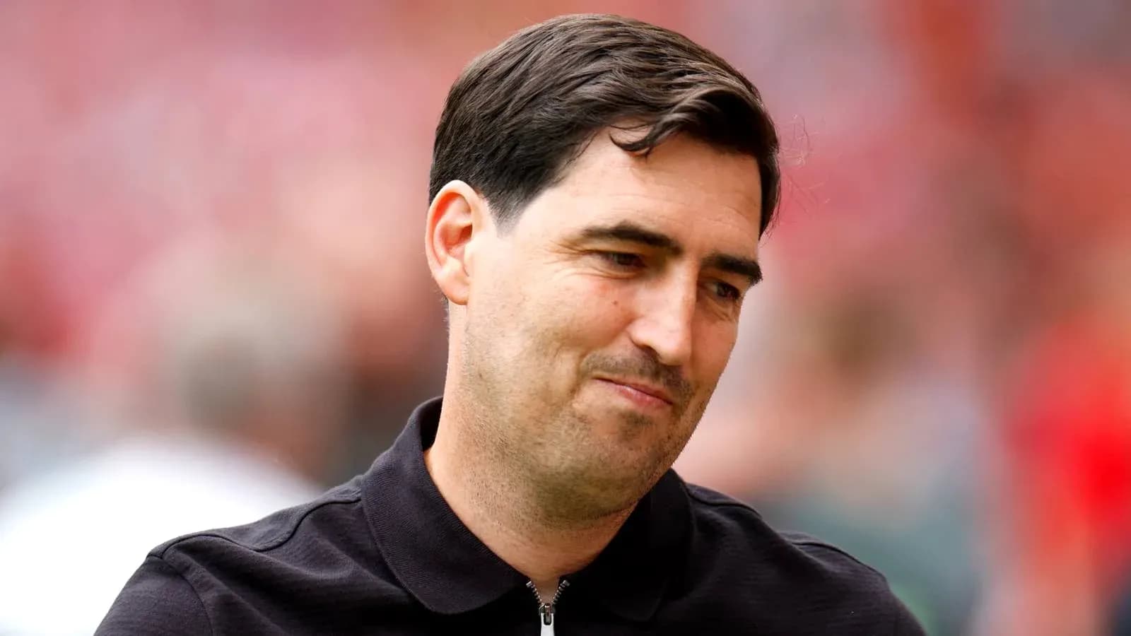Man in black shirt smiling on the field Man in black shirt smiling on the field