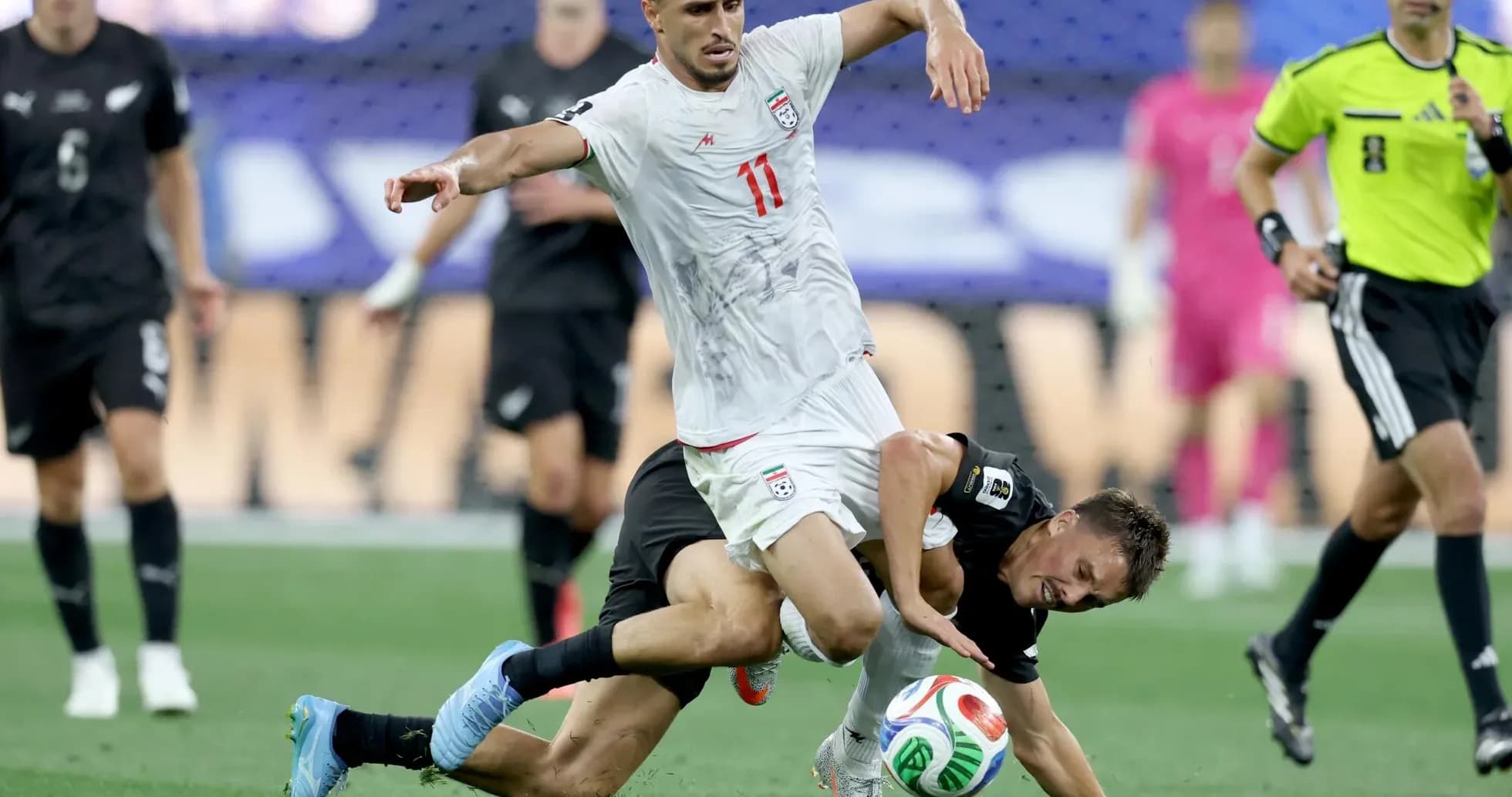 Iran player tackling New Zealand opponent during match Iran player tackling New Zealand opponent during match