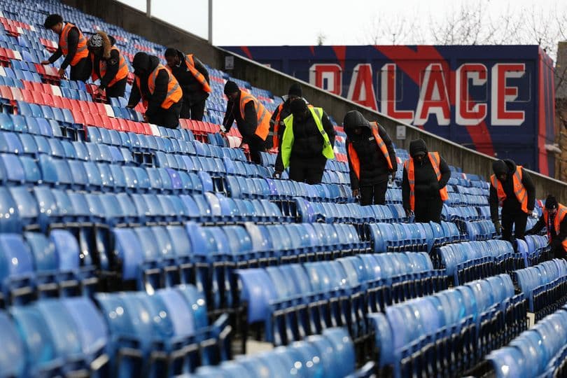 Staff cleaning seats in stadium stands before event Staff cleaning seats in stadium stands before event