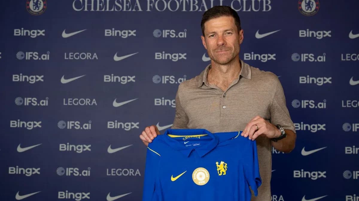 New coach holding Chelsea jersey at press conference New coach holding Chelsea jersey at press conference