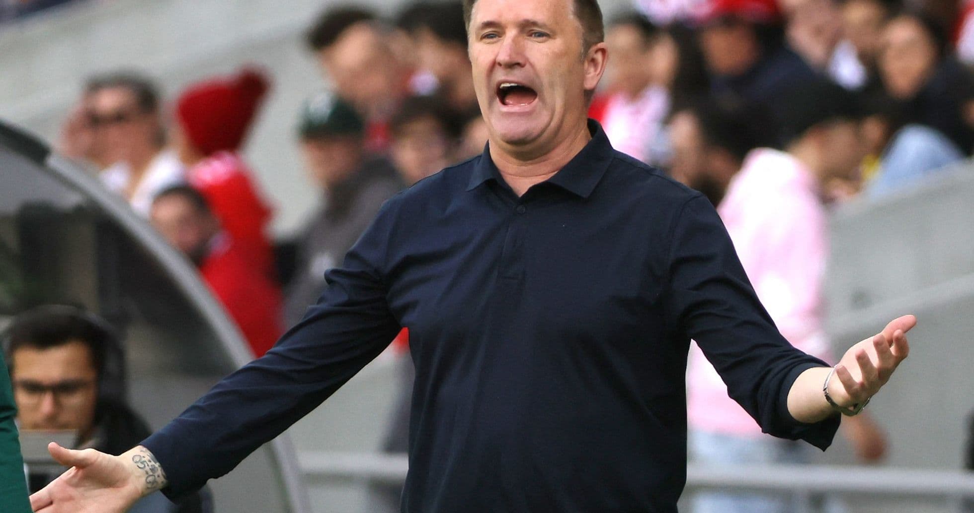 Coach gesturing animatedly during a match Coach gesturing animatedly during a match