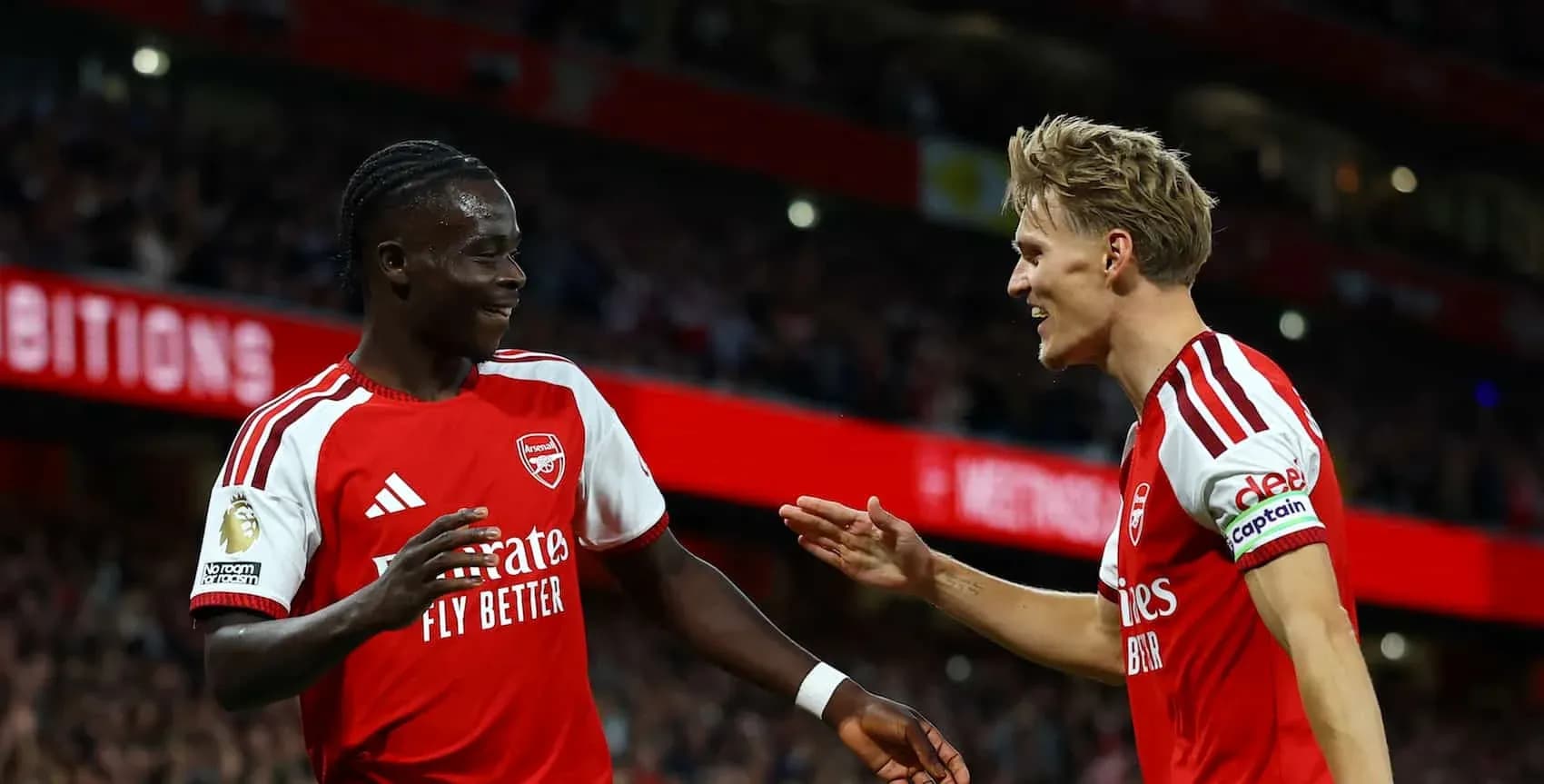 Two Arsenal players celebrating a goal together Two Arsenal players celebrating a goal together